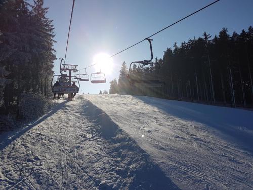 a ski lift going up a snow covered slope at Chalupa na Lipně - Holiday House 1 in Lipno nad Vltavou