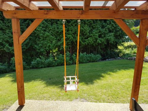 a swing in a gazebo in a yard at Chalupa na Lipně - Holiday House 1 in Lipno nad Vltavou