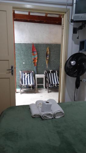 a bedroom with a bed with two towels on it at Suítes o Flautista in Ubatuba