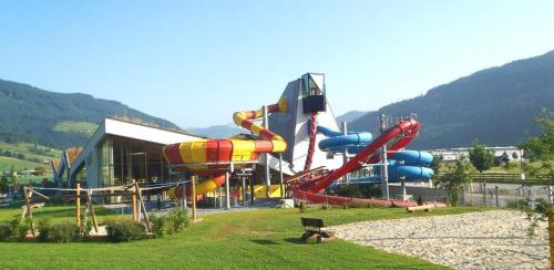 um parque aquático com um escorrega aquático colorido em Baby- und Kinderbauernhof Montaning em Forstau