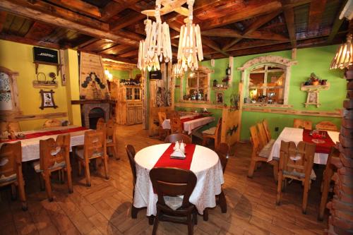 a restaurant with tables and chairs and a fireplace at Apartment Dream Konaci in Kopaonik