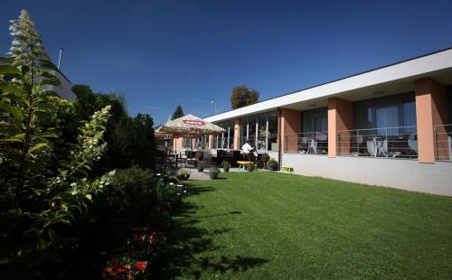 a house with a lawn in front of a building at Penzion a Restaurant Barbora in Kutná Hora