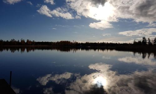 a large lake with the reflection of the sun in the water at Eckerö Camping & Stugor in Eckerö