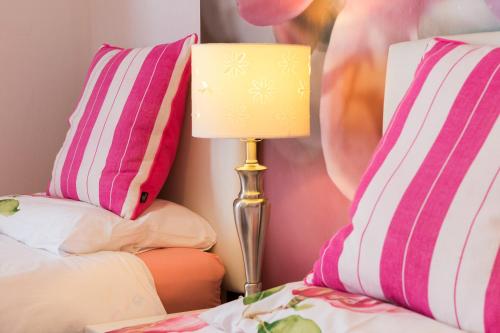 a lamp sitting on a bed next to two pillows at Marine Hotel in Paignton