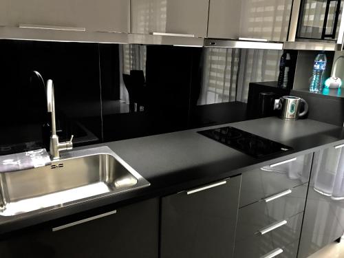 a kitchen with a stainless steel sink and a stove at MOKO Apartment in Warsaw