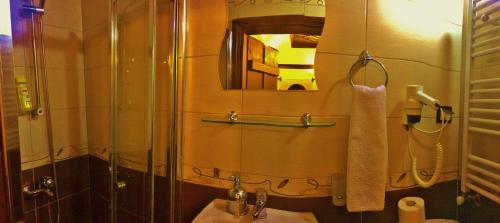 a bathroom with a sink and a shower and a mirror at Beybagi Konak Hotel in Safranbolu