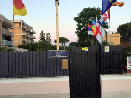 a black fence with flags in front of a building at Il Giardino Di Adriana in Terracina