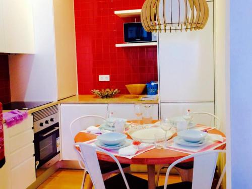 a kitchen with a table with chairs and a red wall at Apartments Alfacinha Ajuda in Lisbon