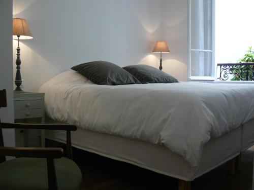 - une chambre avec un lit avec deux oreillers et une fenêtre dans l'établissement La Cour du 5ème - Chambre d'hôtes, à Paris