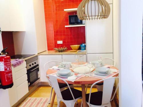 a kitchen with a table with chairs and a red wall at Apartments Alfacinha Ajuda in Lisbon
