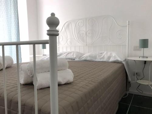 a bedroom with a white bed with towels on it at ZI' MARI' - Via Roma in Polignano a Mare