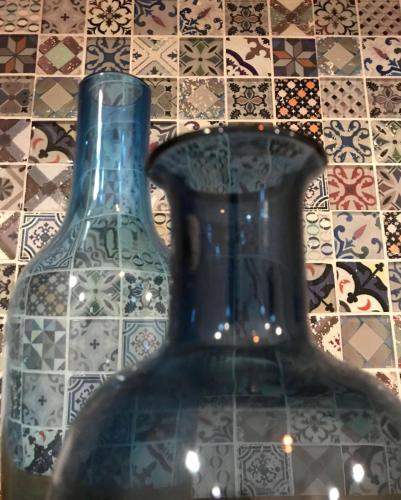 a blue glass vase sitting in front of a tile floor at Zì Marì - Via Sirene in Polignano a Mare