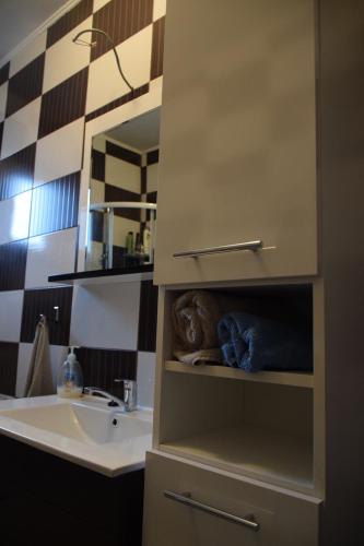 W łazience znajduje się umywalka, lustro i umywalka. w obiekcie Guest house Ema w mieście Daruvar