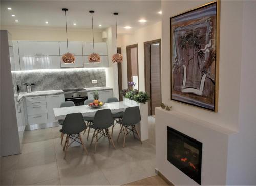 a kitchen and dining room with a white table and chairs at Alke Homme in Athens