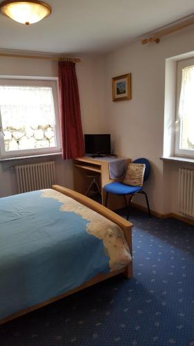 a bedroom with a bed and a desk with a computer at Cèsa Chri e Sofì in Campitello di Fassa