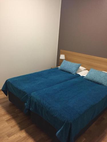a bedroom with a bed with a blue blanket at Ruka Chalets Royal Apartments in Ruka