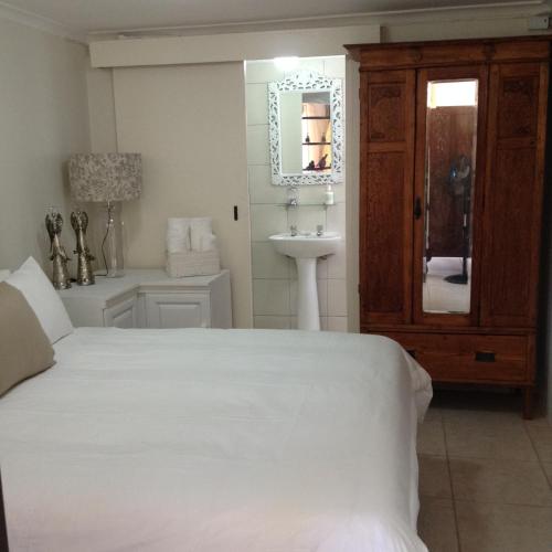 a bedroom with a bed and a sink and a mirror at Broadway in Durban