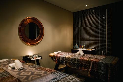 a room with two beds and a mirror on the wall at Noiva do Mar in Lourinhã