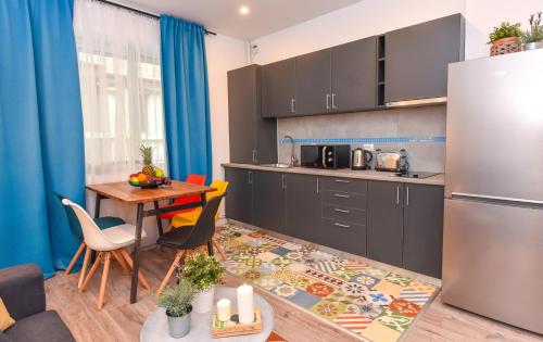a kitchen with a table and a refrigerator at Parliament & River View Apartments in Bucharest