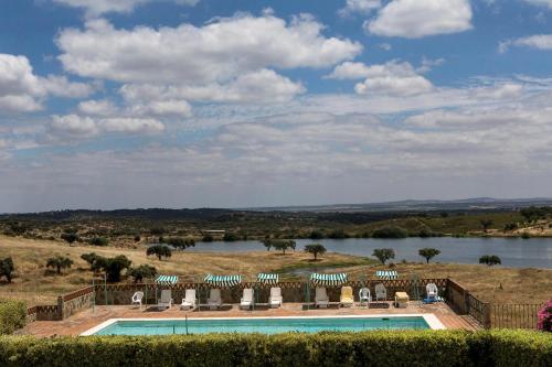 a swimming pool with a view of a river at Naveterra-Hotel Rural in Alandroal