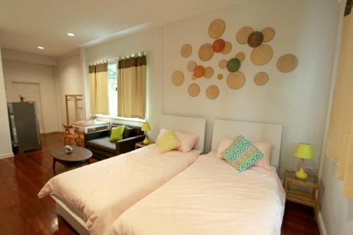 une chambre avec un lit et un salon dans l'établissement The Serene House Bangkok, à Bangkok