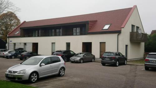 a building with cars parked in a parking lot at Maria Rooms in Kuressaare