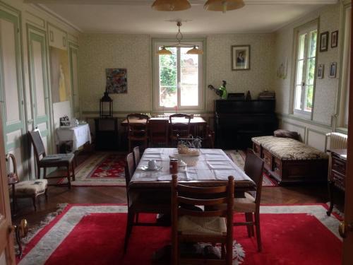 une salle à manger avec une table et des chaises ainsi qu'une chambre dans l'établissement La tourelle, à Vascoeuil