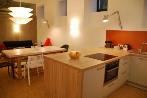 eine Küche und ein Esszimmer mit einem Tisch und einer Arbeitsplatte in der Unterkunft My Home in Vienna - Smart Apartments - Landstraße in Wien