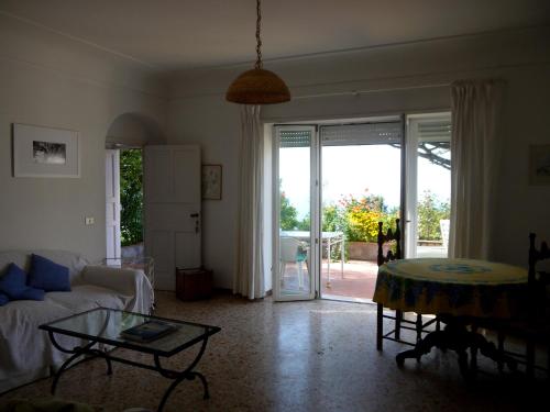 ein Wohnzimmer mit einem Sofa und einem Tisch in der Unterkunft Villetta Rosetta in Capri