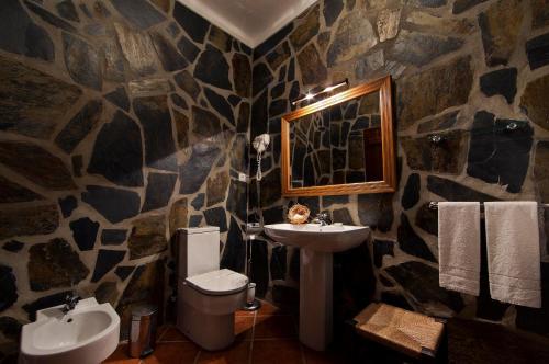 Baño de piedra con lavabo y aseo en Naveterra-Hotel Rural, en Alandroal