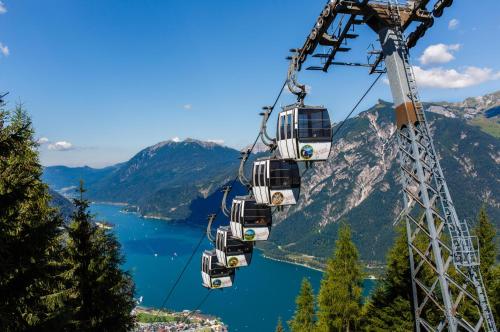 a gondola ride over a lake in the mountains at Alpenvital Tirol Appartements in Pertisau
