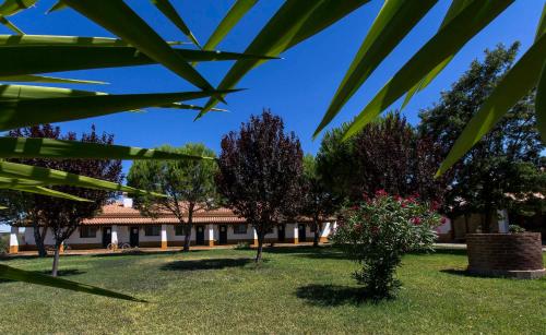 a garden with trees and a building in the background at Naveterra-Hotel Rural in Alandroal