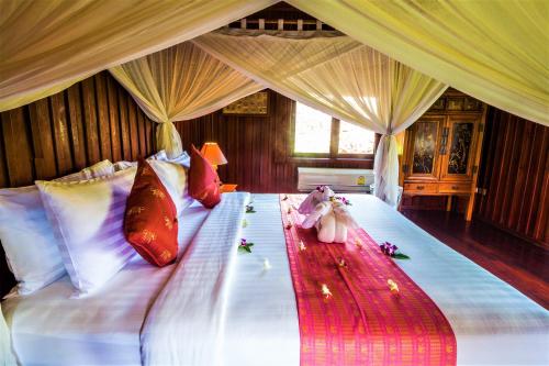 a bed with two stuffed animals sitting on it at Erawan Villa Hotel in Bangrak Beach