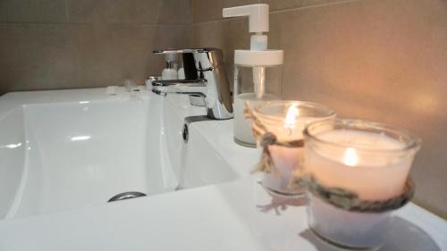 a bathroom sink with a faucet and candles on it at TOP APARTMENT ÁTICO con TERRAZA con vistas al ENCIERRO SAN FERMÍN in Pamplona