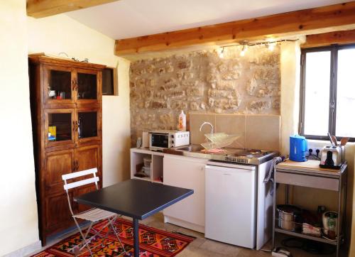 une petite cuisine avec une petite table et une table dans l'établissement Maison du Manescau, à Saint-Pierre-de-Vassols