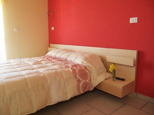ein Schlafzimmer mit einem Bett mit einer roten Wand in der Unterkunft B&B La Rosa dei Venti in Montesilvano