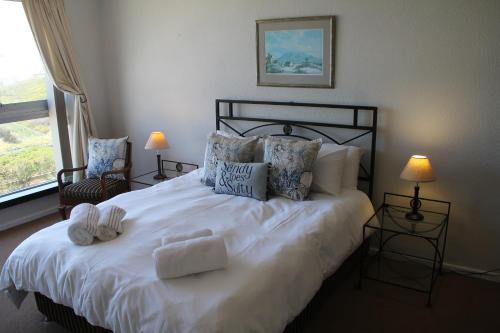 um quarto com uma grande cama branca com almofadas em Bloubergviews em Bloubergstrand