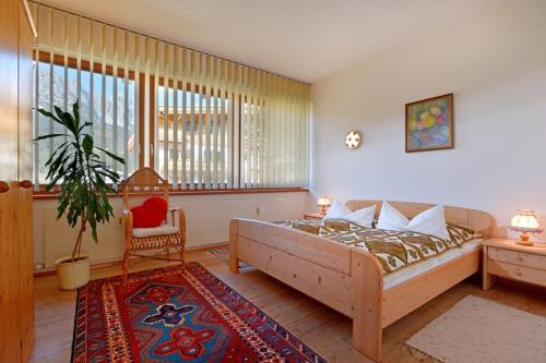 - une chambre avec un lit, une chaise et une plante dans l'établissement Haus Friederike - "Apartment KaiserTor", à Ellmau