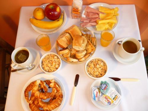 una mesa cubierta con platos de comida y bebida para el desayuno en Hosteria Ymaz en Villa Gesell
