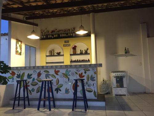 a bar with two stools in a room with a fireplace at Pousada Vila Mar in Beberibe