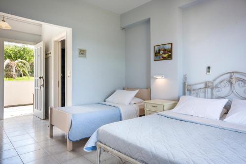 a bedroom with two beds and a balcony at Panorama Fanari studios and apartments in Argostoli