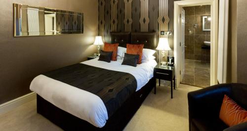 a hotel room with a large bed and a bathroom at Applegarth Villa Hotel & Restaurant (Adult Only) in Windermere