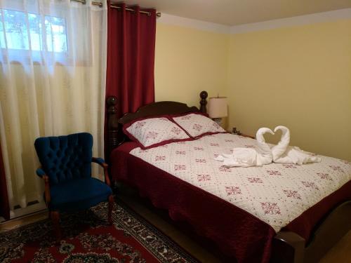 1 dormitorio con 1 cama y 1 silla azul en M and D BnB, en St. John's