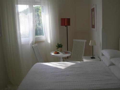 a bedroom with a bed and a table and a window at Il San Francesco Charming Hotel in Sabaudia