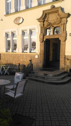 a building with a table and chairs in front of it at Bohemica Apartments in Děčín