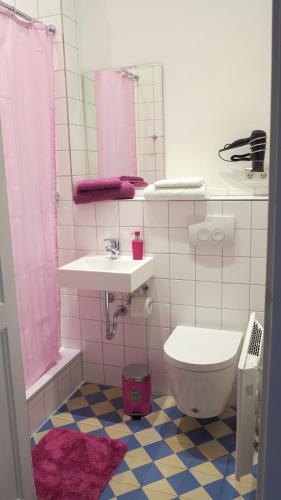 テュービンゲンにあるAppartements in zentraler Lageのピンクのバスルーム(トイレ、シンク付)
