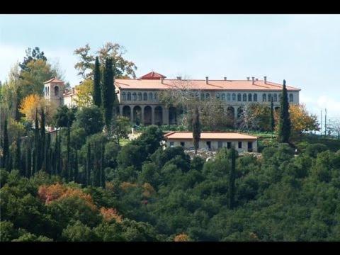 a large building on top of a hill with trees at Olympios Zeus Hotel in Kato Zachlorou