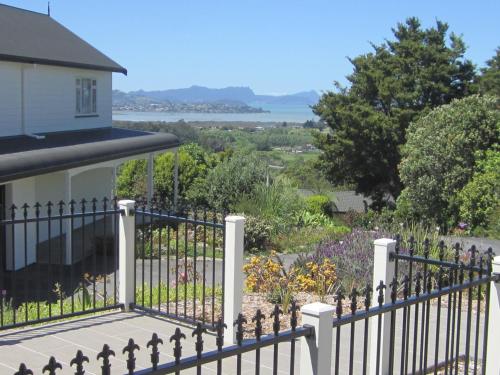 a fence in front of a house with a view at Hyecroft Lodge in Whangarei