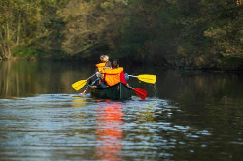 two people in a boat in the water at Spreewaldferienwohnungen in Lübben