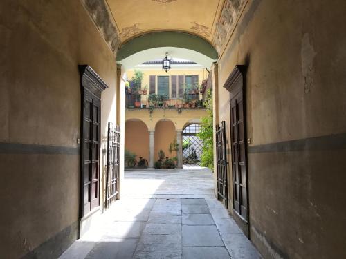 um beco num edifício antigo com portas e plantas em Violino azul em Cremona